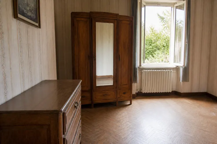 La même chambre vidée et nettoyée : fenêtre ouverte, sol dégagé et pièce claire.
